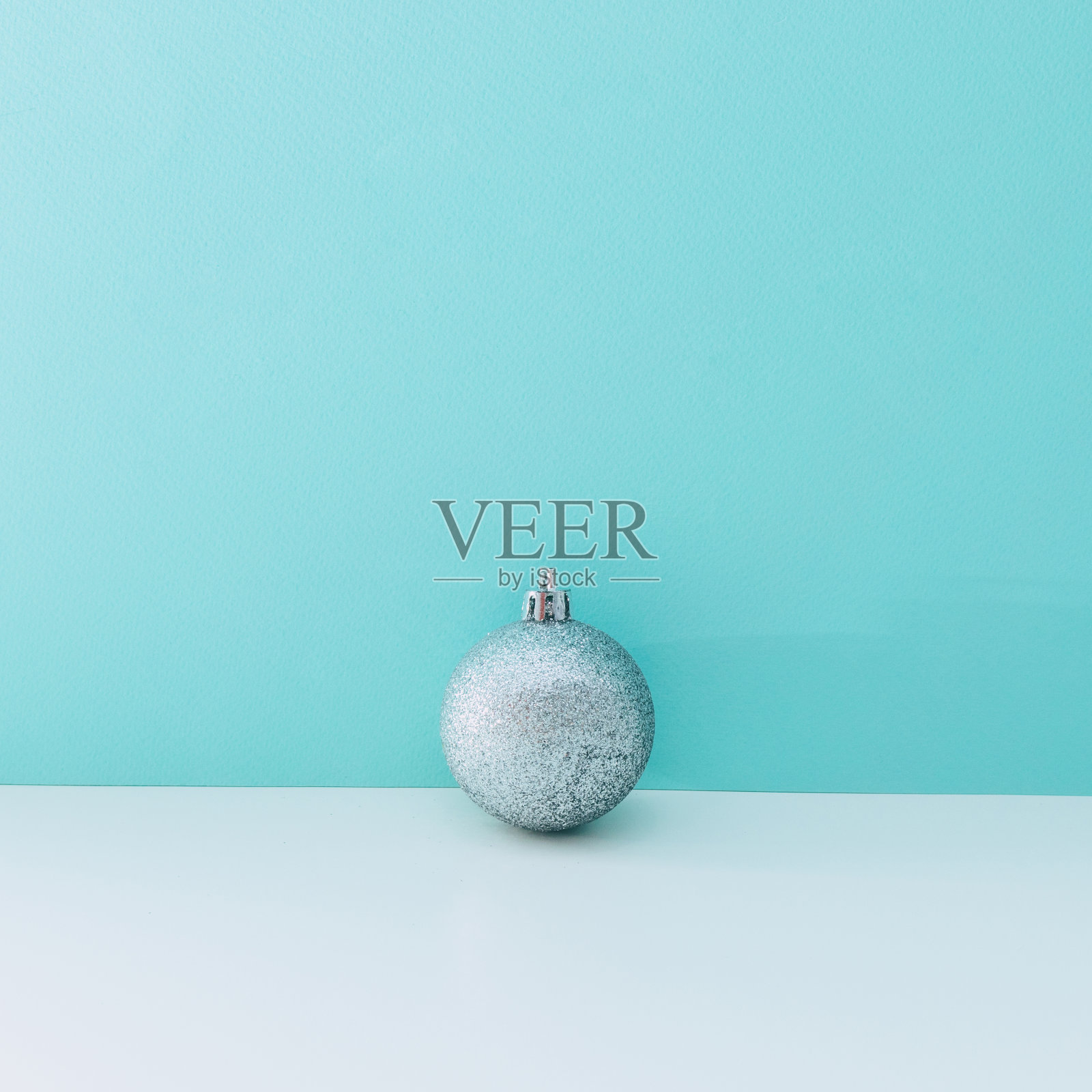 白色和蓝色背景上的一个银色装饰。圣诞节和新年的概念。布局静物,复制空间照片摄影图片