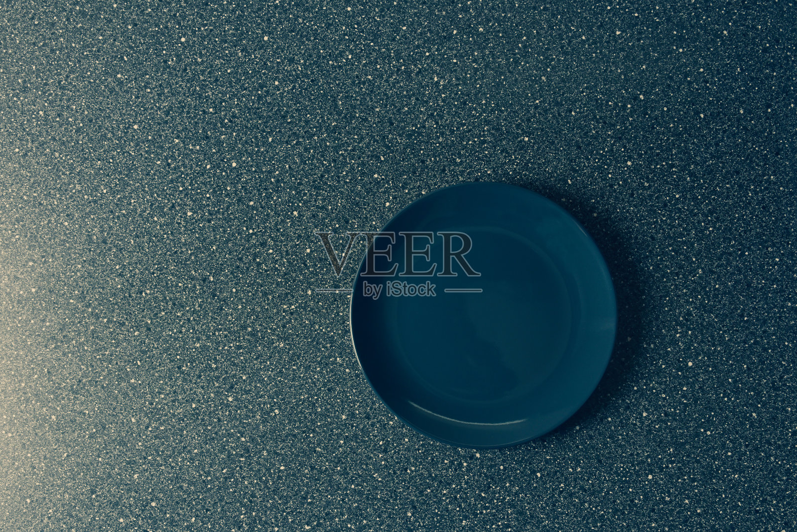 灰色的石头桌子上放着灰色的盘子。从以上观点。照片摄影图片