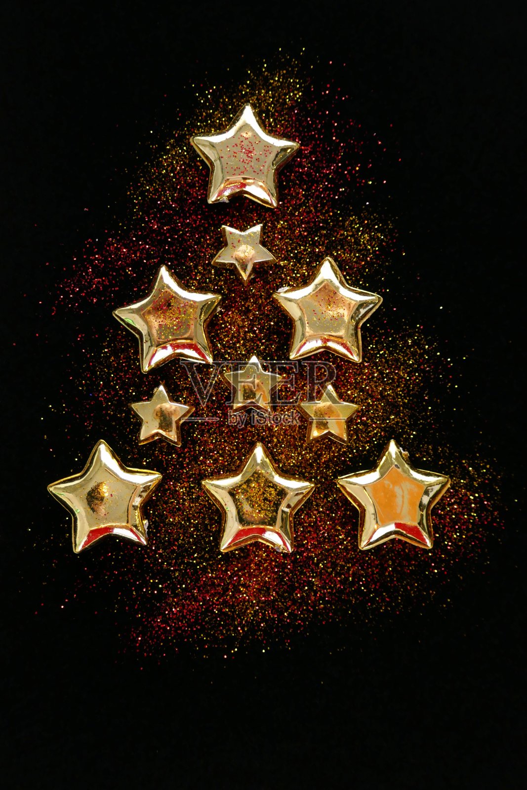 圣诞和新年闪闪发光的背景。圣诞树由金属星星和闪闪发光的黑色背景。寒假背景照片摄影图片