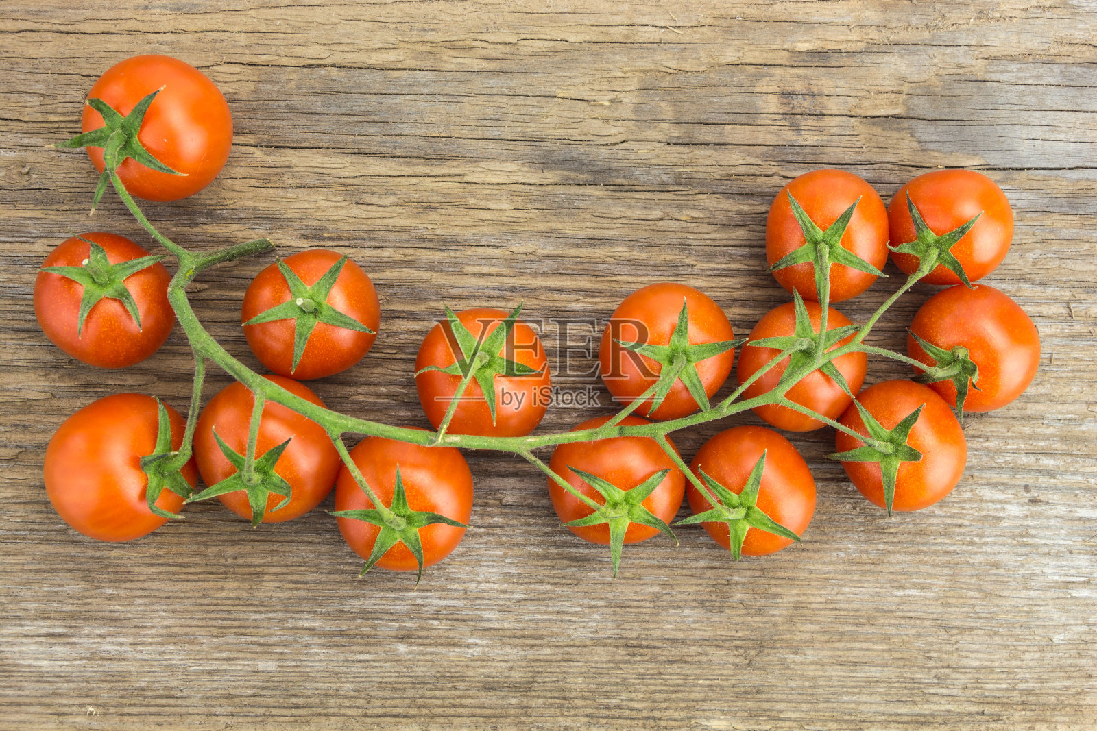 一堆樱桃西红柿,放在木头表面上。照片摄影图片