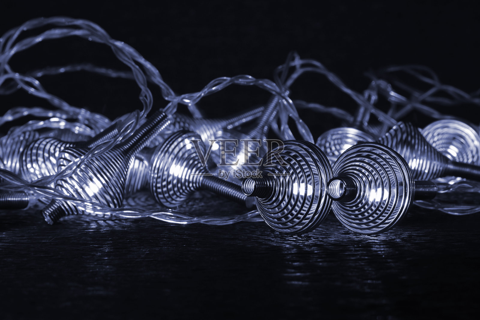 发光的金属弹簧圣诞花环在黑暗的背景照片摄影图片