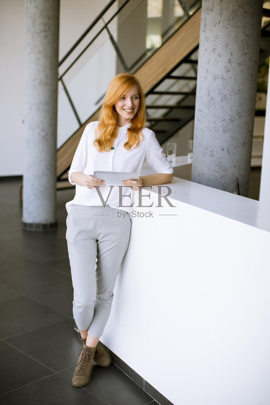 一个红发美女在用平板电脑照片摄影图片