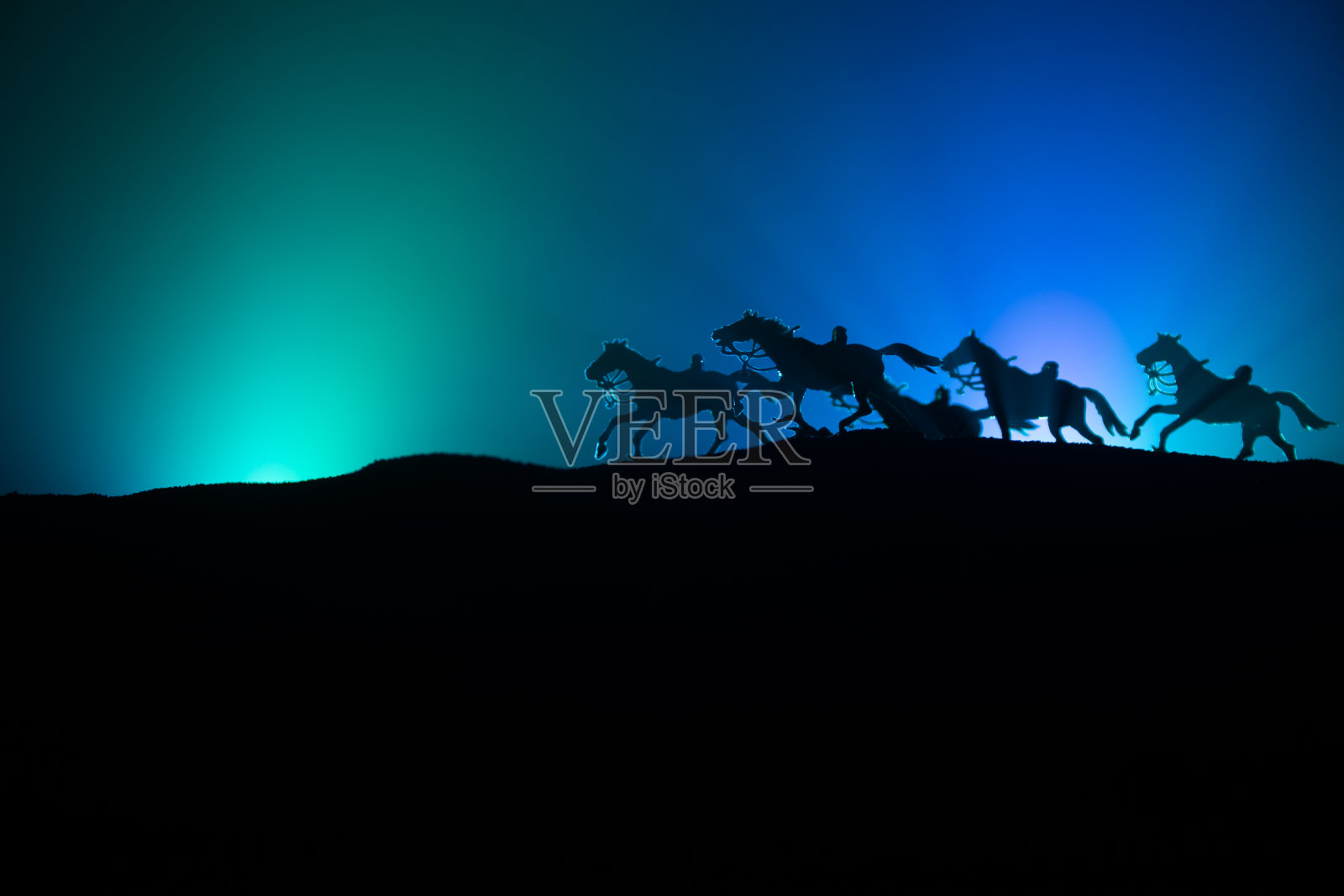 马的剪影在一个山的顶部,在黑暗色调的雾背景。创造性的成分。照片摄影图片