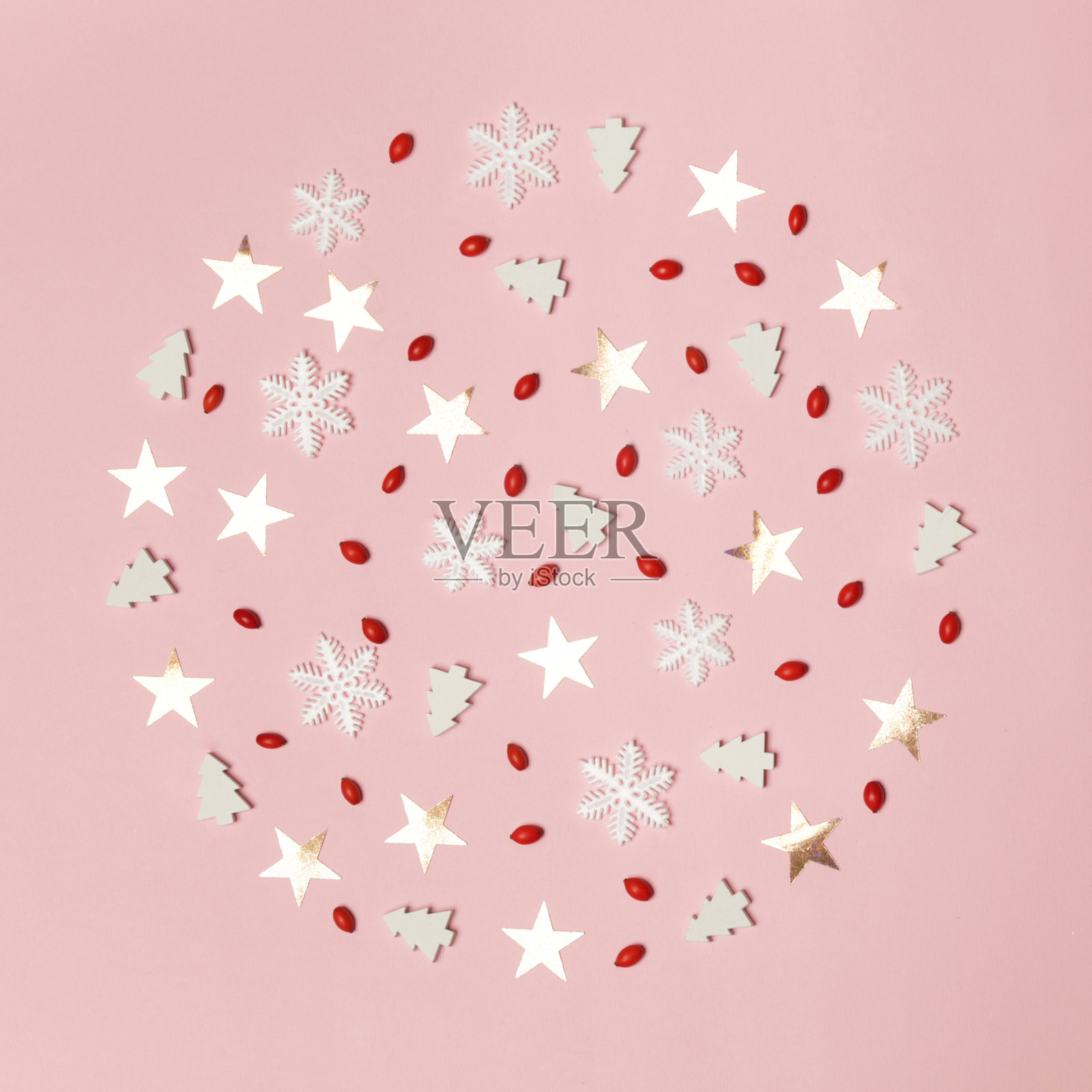 优雅的冬季背景。红色的浆果、雪花、星星和淡粉色背景下的小圣诞树。圣诞节、寒假、新年概念。照片摄影图片