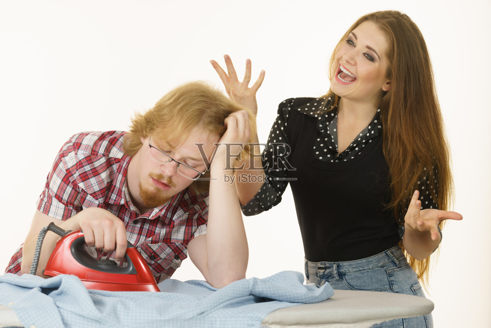 快乐的女人和无聊的男人在熨衣服照片摄影图片