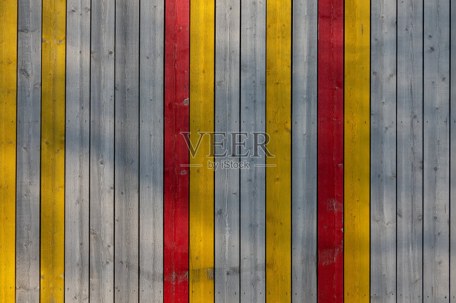 垂直木板的墙。有些板子没有涂漆,部分漆成黄色和红色。背景。纹理。照片摄影图片