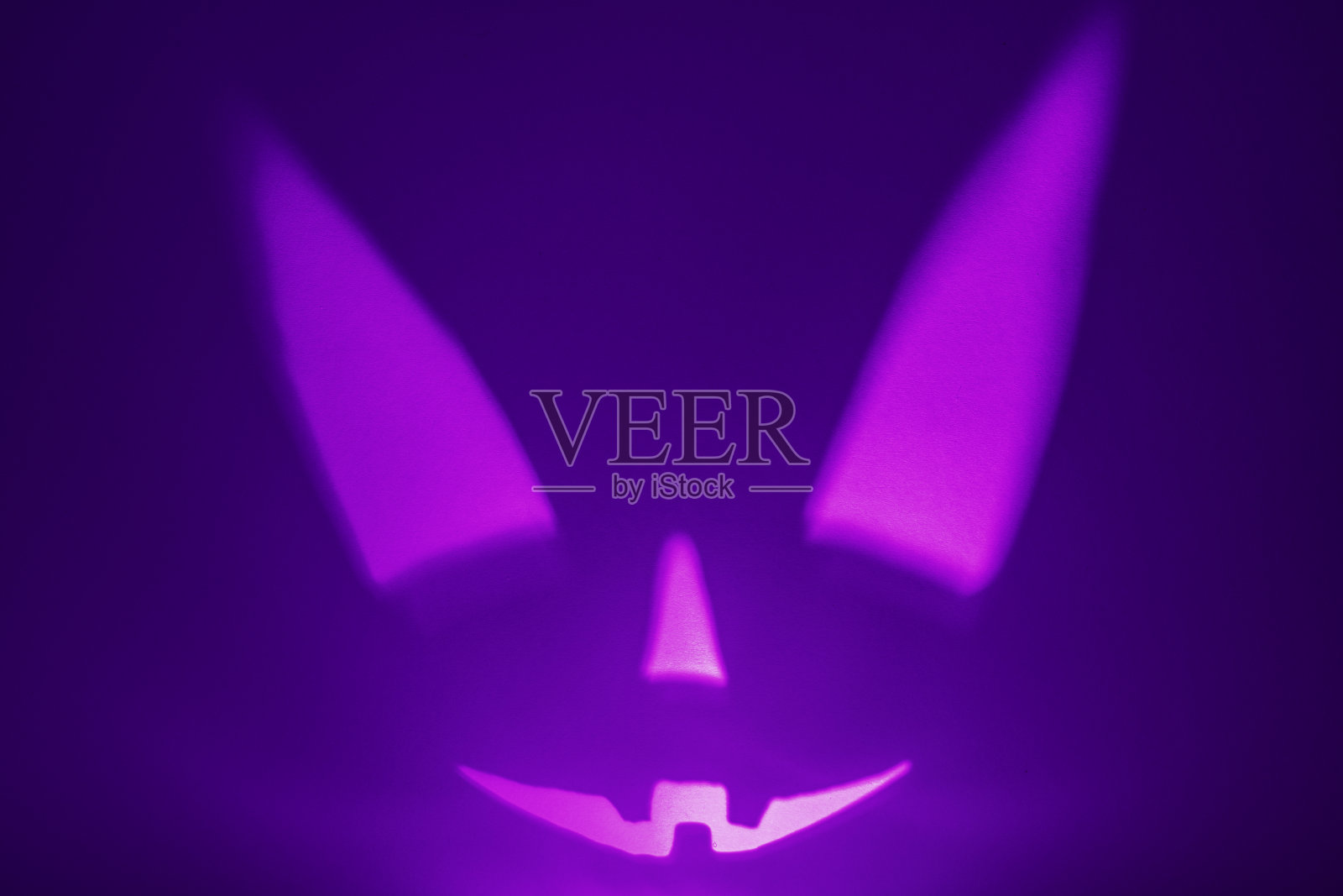 万圣节可怕的脸在紫色的背景。可怕的微笑的脸。假日恐怖背景照片摄影图片