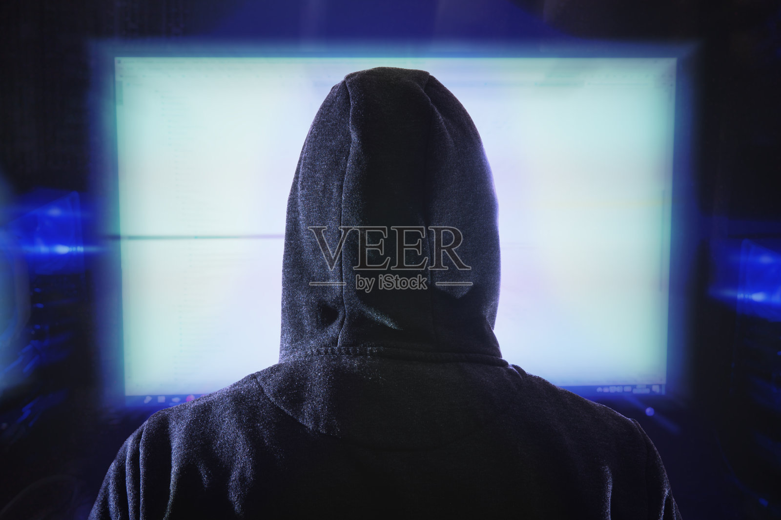 匿名黑客正在盯着电脑显示器。从behin照片摄影图片