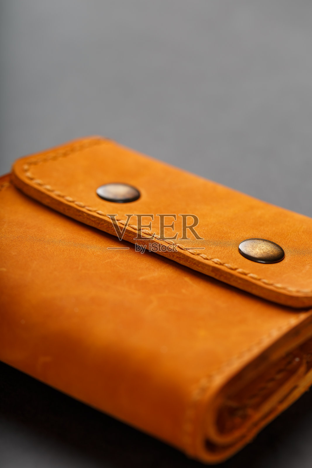 棕色钱包,皮夹制成的真皮Nubuck在一个黑暗的背景。皮革工艺品的元素手工制作照片摄影图片