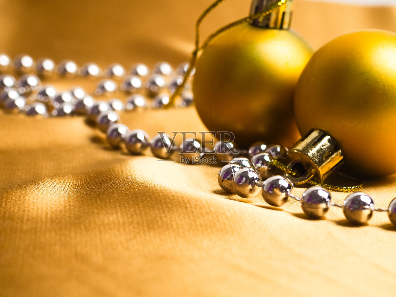 金色背景的圣诞装饰,金色的球和丝绸织物。圣诞贺卡,文字空间。新年的装饰是黄色的照片摄影图片
