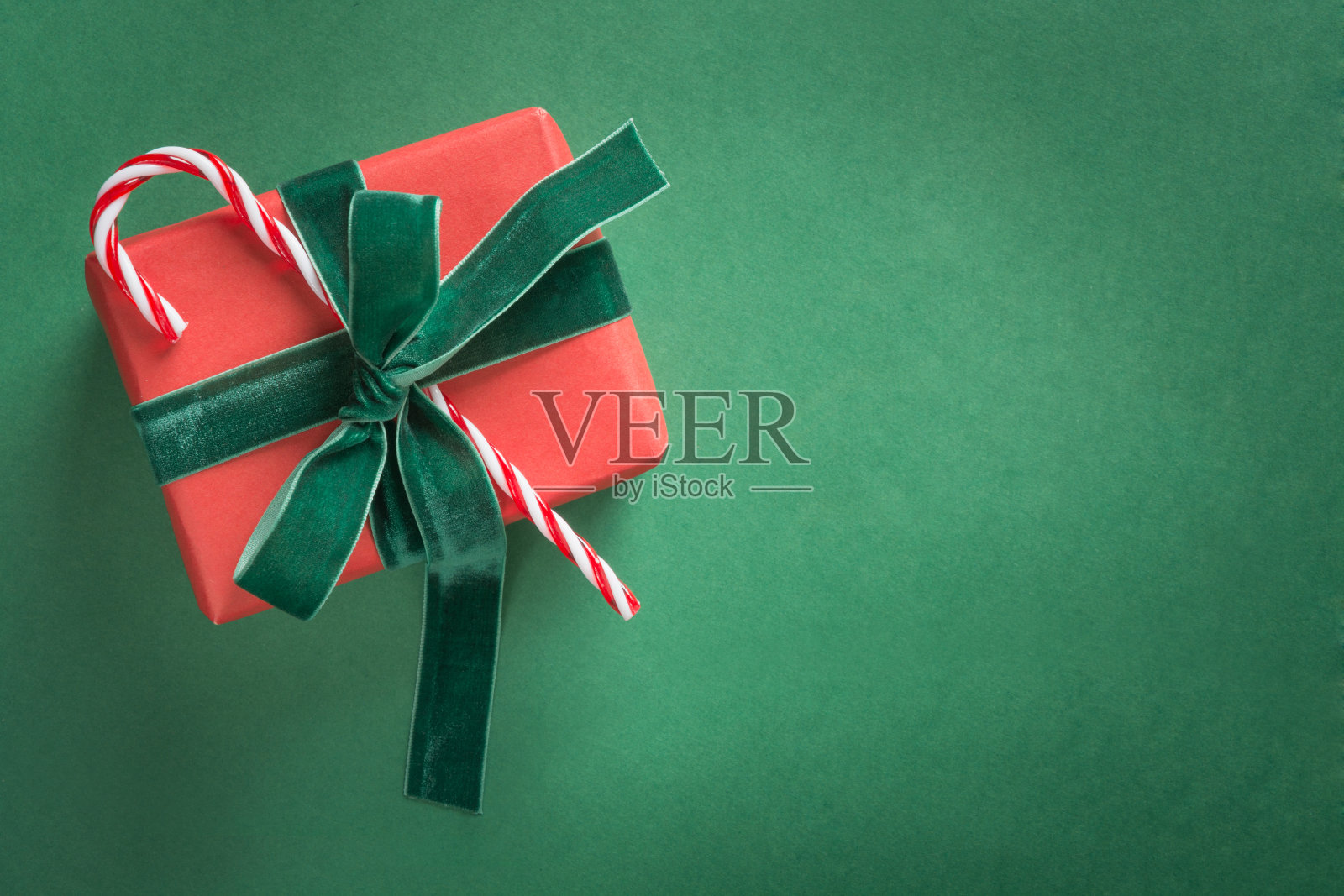 圣诞礼物用绿色的丝绒丝带系在绿色上照片摄影图片