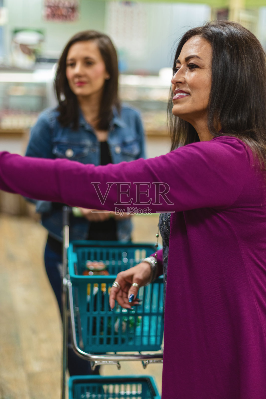 女性混合种族的朋友一起在高档的当地肉类和杂货市场购物照片摄影图片