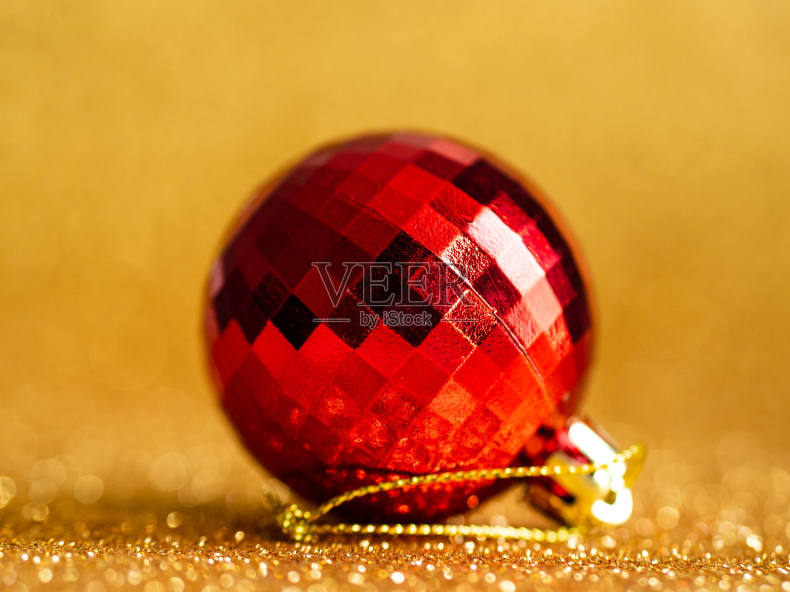 红色圣诞球上的黄金闪闪背景。照片摄影图片