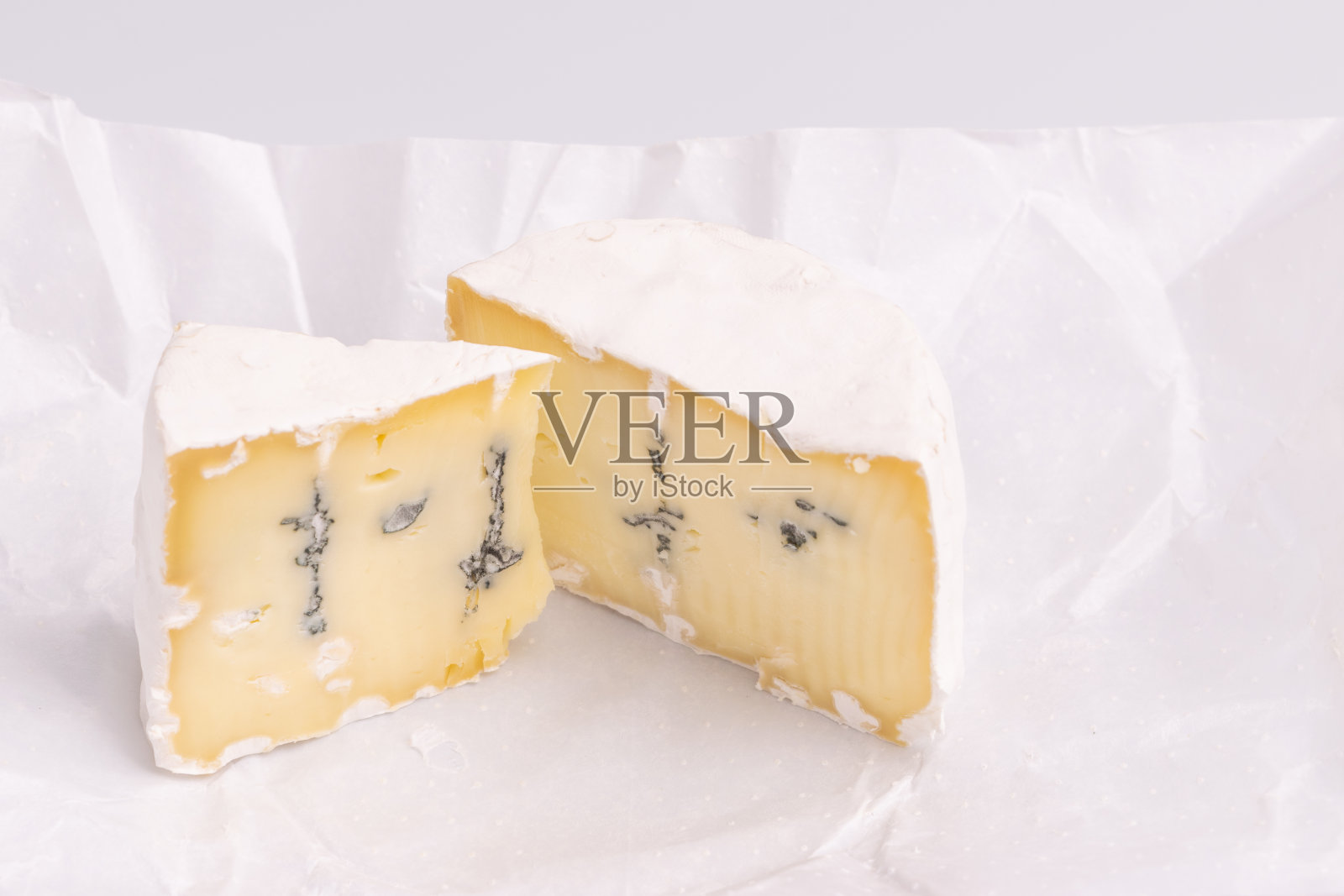 蓝色奶酪白色表面,孤立在白色背景上,柔和的光线,照相馆照片。戈贡佐拉干酪和卡芒贝尔/布里干酪混合。照片摄影图片