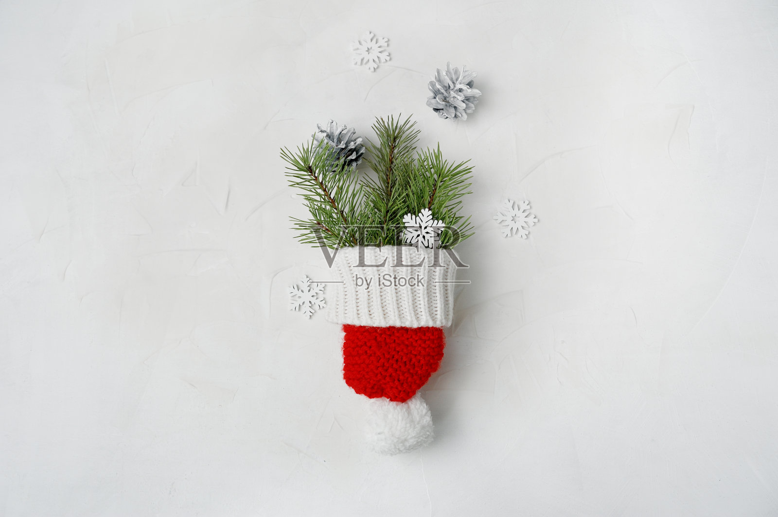 圣诞老人的红帽在木制的背景。圣诞背景用锥形和雪花平铺,俯视图照片摄影图片