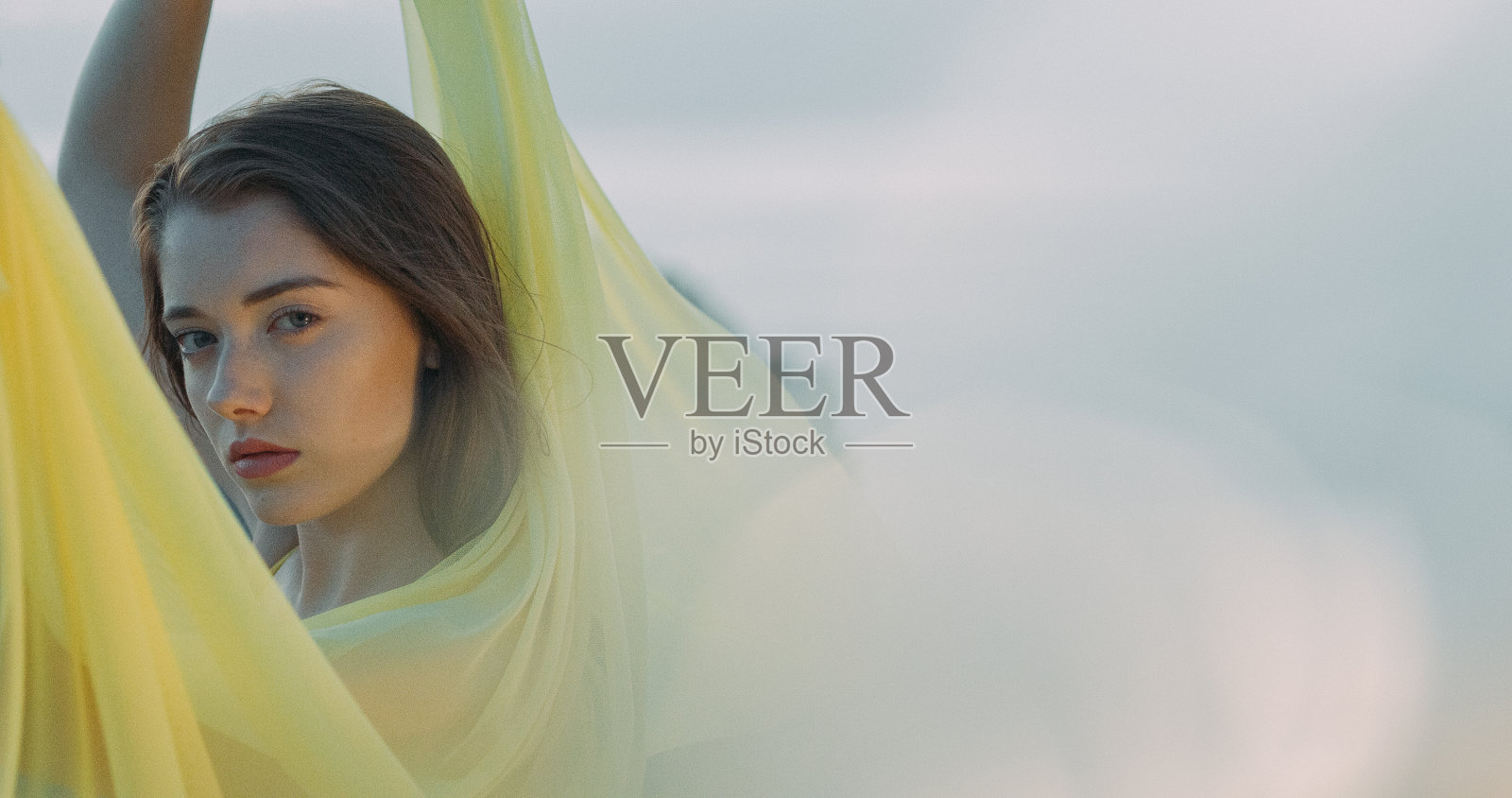 诱人的女人享受着自由,躲在披肩后面照片摄影图片