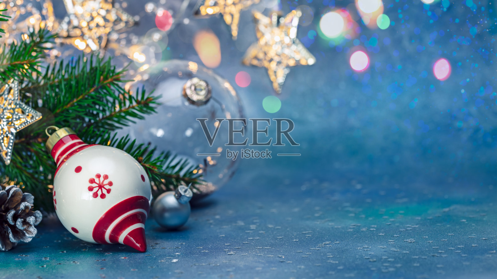 喜庆新年蓝色背景。圣诞树树枝,玻璃球和发光的灯照片摄影图片