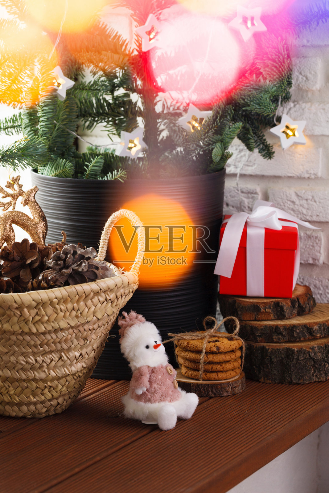 圣诞节的内部。木制的窗台上装饰着一棵圣诞树,一个柳条篮子,里面有松果、圣诞树玩具和花环灯照片摄影图片