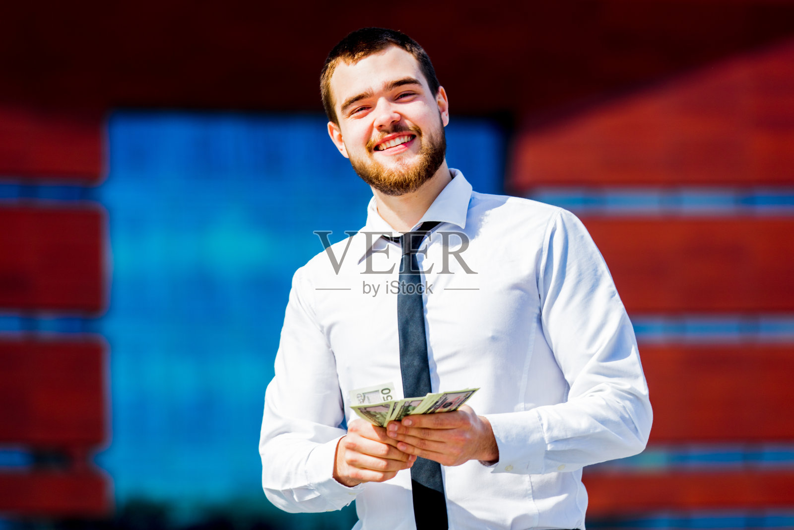 年轻的商人拿着现金照片摄影图片