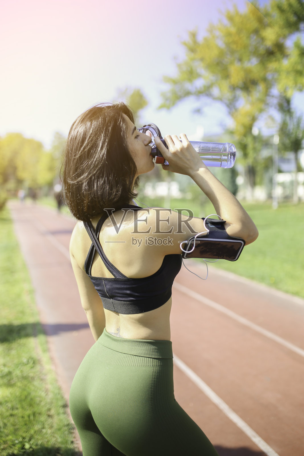 年轻女子在赛道上喝水照片摄影图片