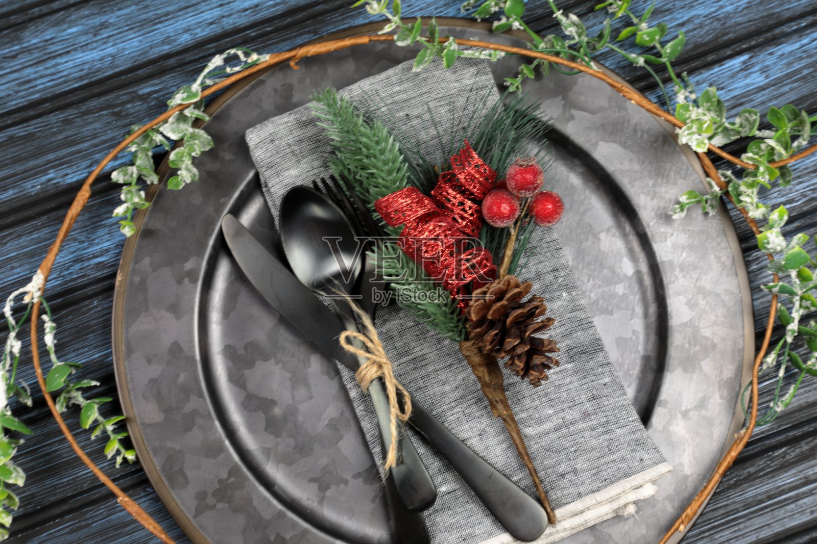 餐桌设置的头顶视图-一个盘子,勺子,叉子和刀的圣诞装饰照片摄影图片