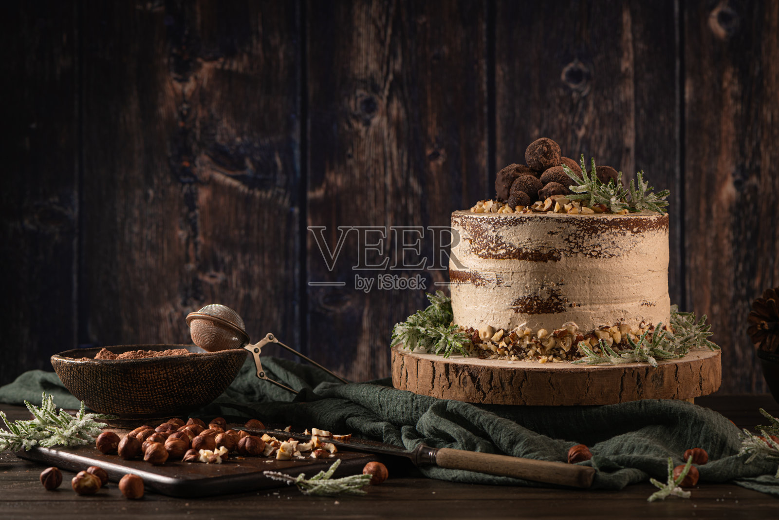 美味的裸巧克力和榛子蛋糕放在质朴的木质厨房台面上。照片摄影图片