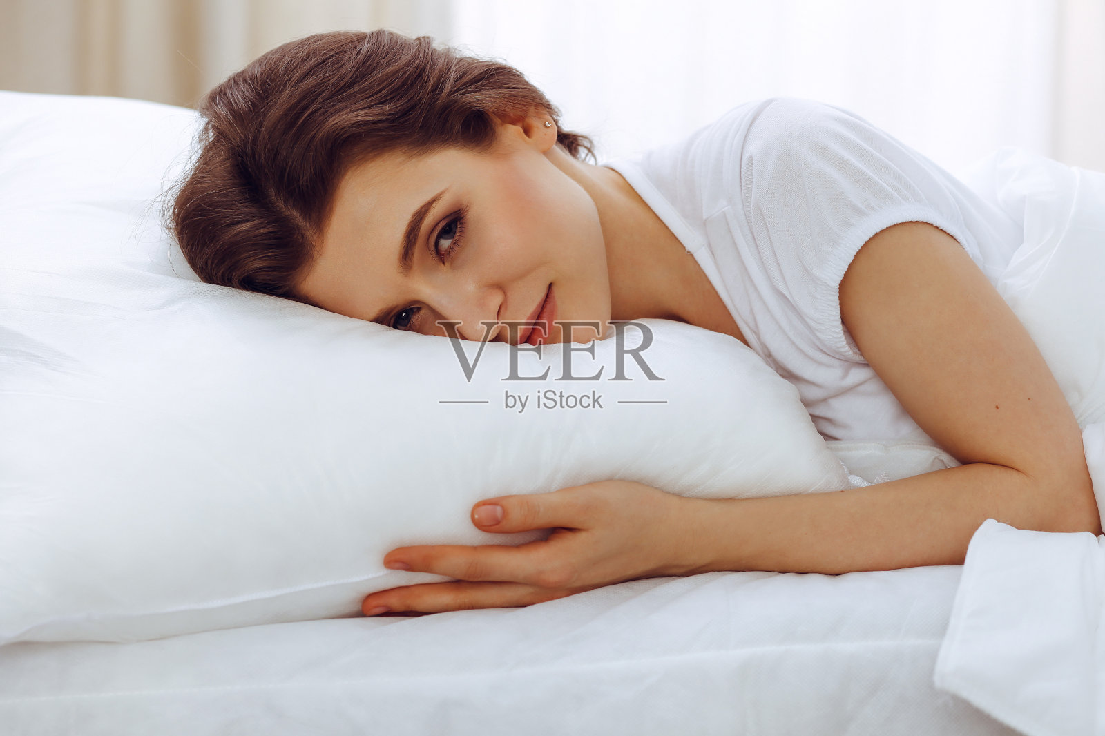 美丽的年轻女子躺在床上睡觉。快乐和休息的概念,恢复积极的生活照片摄影图片