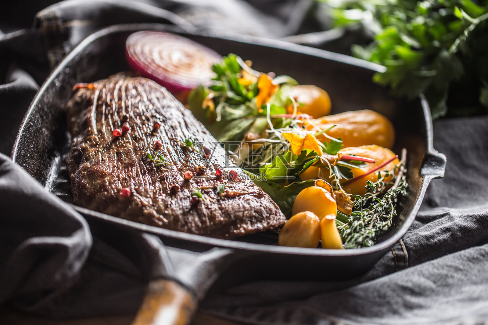 烤盘上的牛腩牛排配蒜蓉和香草装饰照片摄影图片