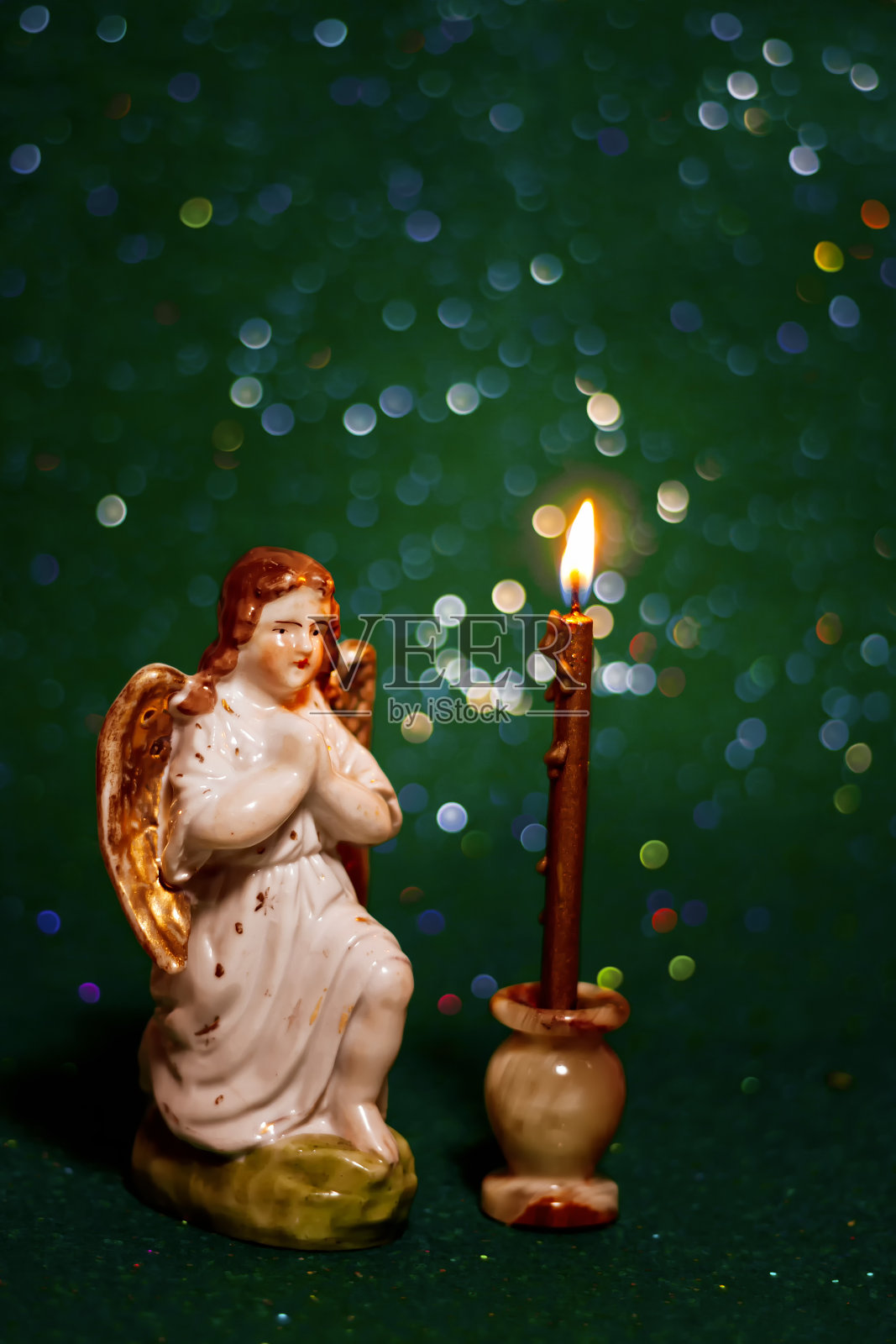 瓷天使与蜡烛,以散景为背景照片摄影图片