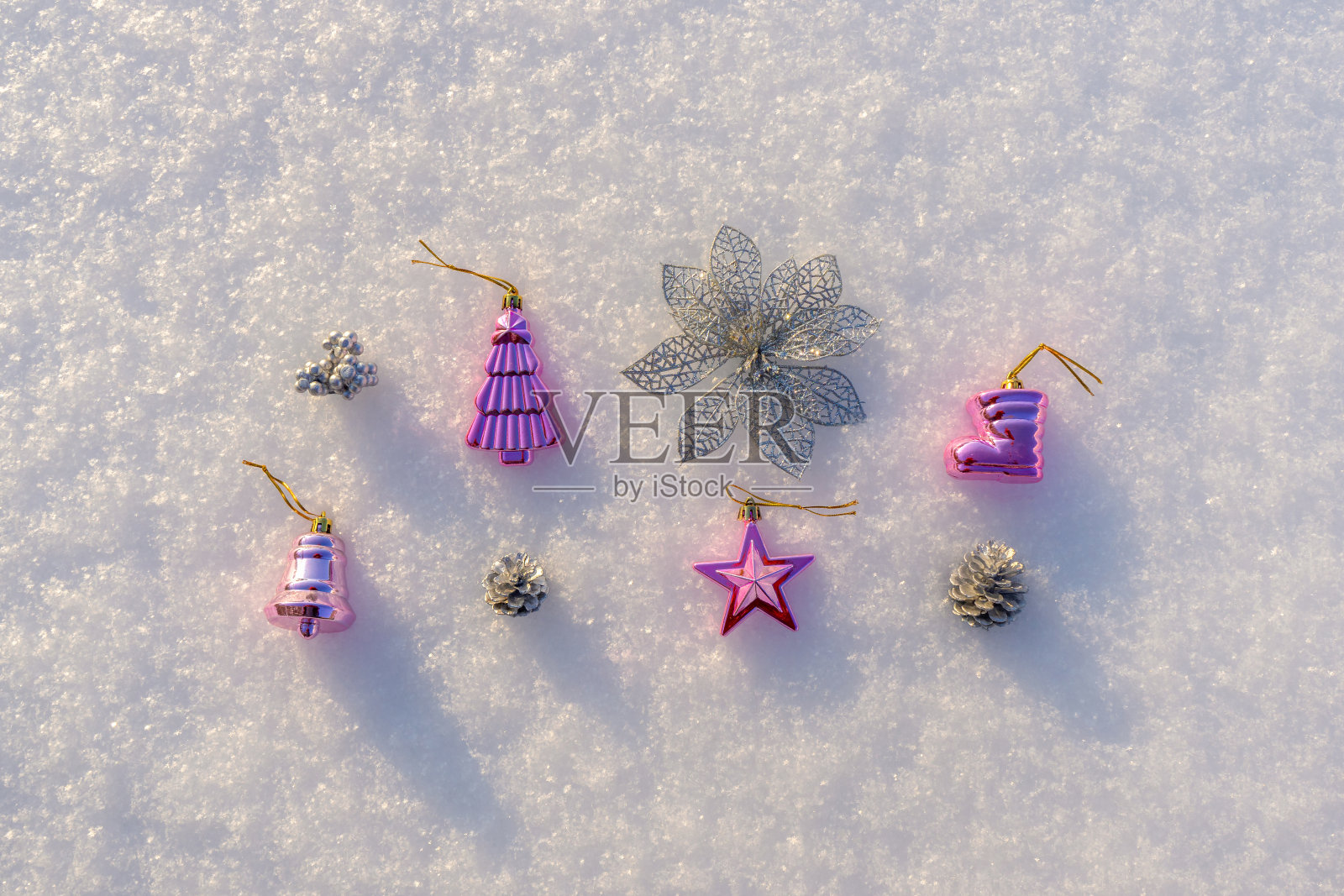 在阳光明媚的冬日里,装饰物品和迷你圣诞玩具躺在洁白的新雪上。寒假贺卡。圣诞快乐,新年快乐。平躺,俯视图照片摄影图片