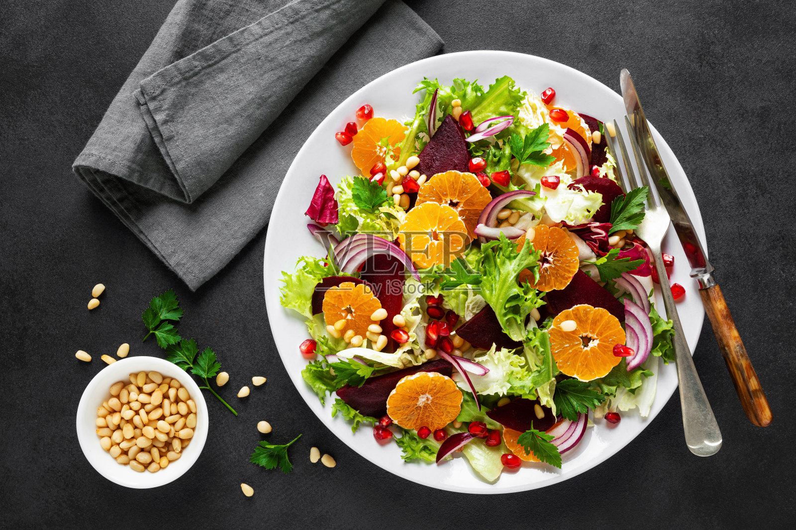 圣诞沙拉配煮甜菜,红洋葱,橘子,石榴,欧芹,松子和莴苣叶照片摄影图片