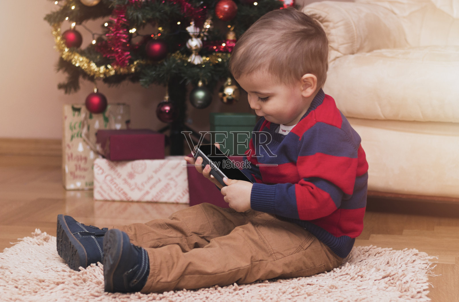 圣诞节期间男孩用手机的照片照片摄影图片