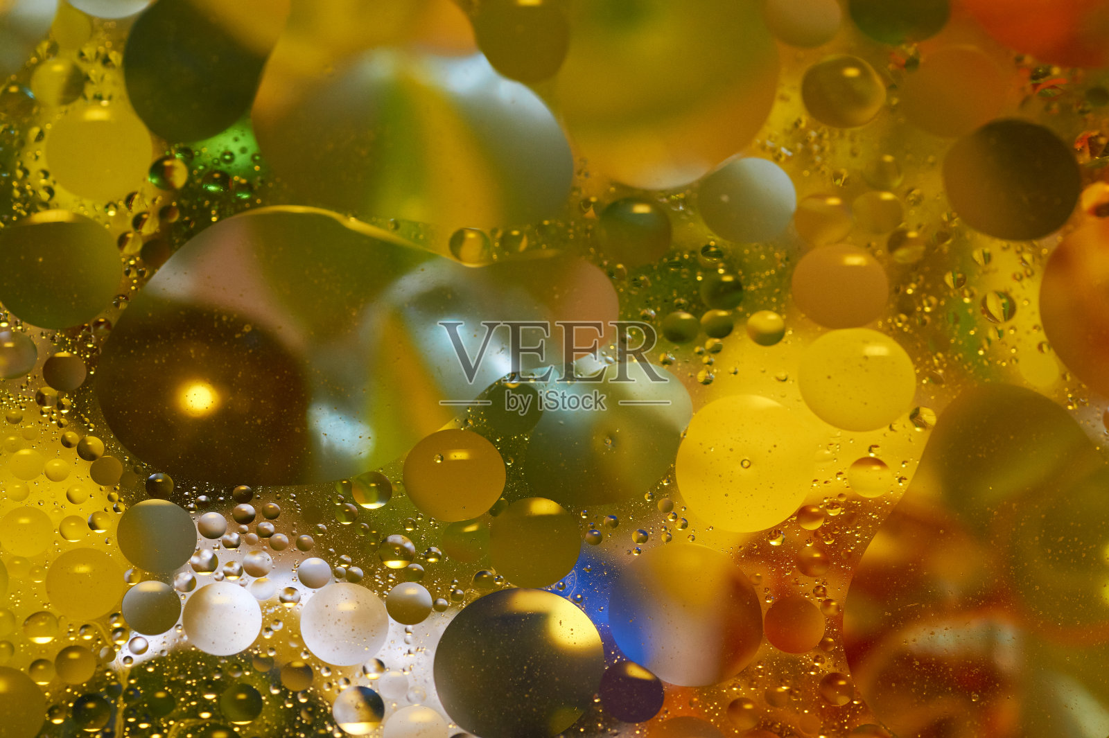 水面上漂浮着五颜六色的、黄色的油滴。照片摄影图片