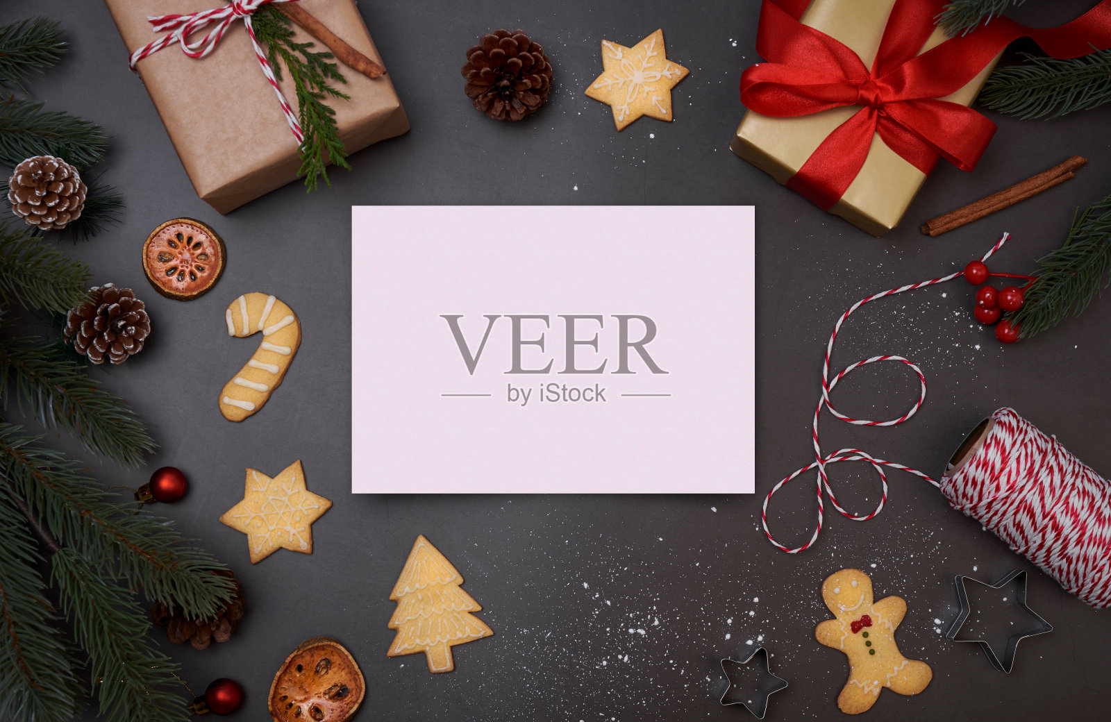 圣诞明信片与装饰礼盒和圣诞饼干在黑色的背景。冬天,新年的概念。平铺,俯视图,拷贝空间。照片摄影图片