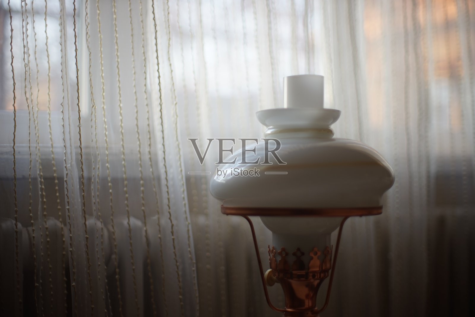 窗户背景上的复古灯,上面有电池和薄纱。照片摄影图片