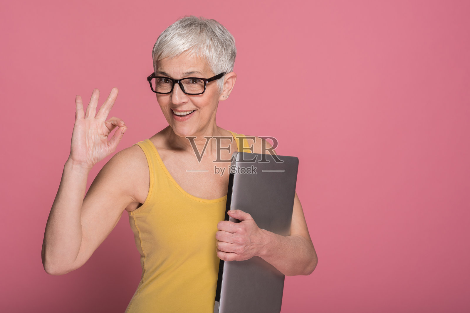 一个满意的老女人拿着笔记本电脑的肖像照片摄影图片