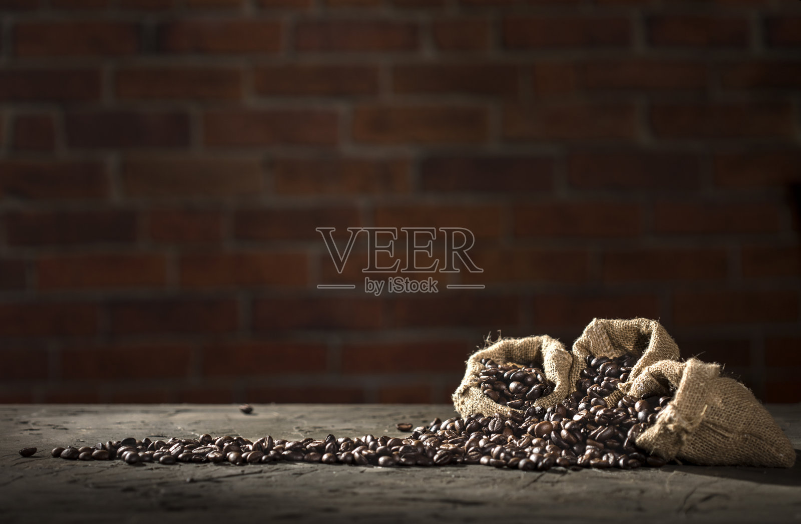 麻袋与咖啡豆在红色砖墙的背景与复制空间照片摄影图片