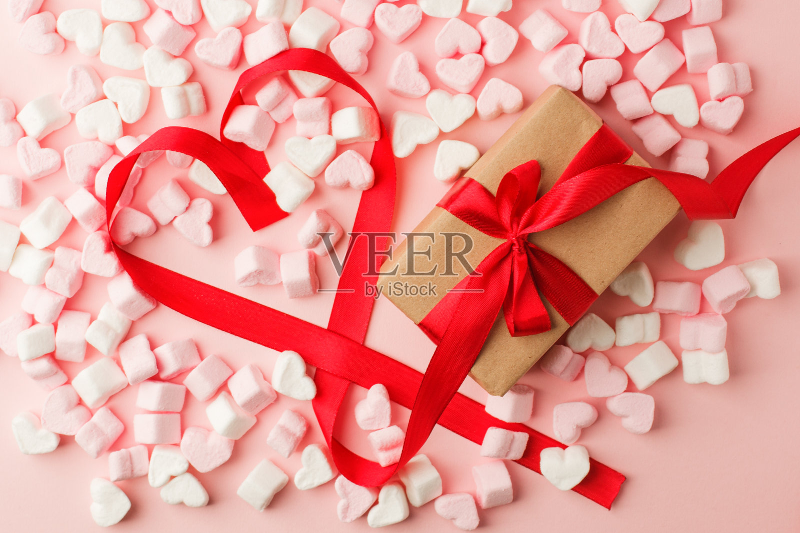 礼品盒与红色丝带心弓,复制空间为您的文字,快乐的情人节背景,甜蜜的棉花糖在粉红色的桌子照片摄影图片
