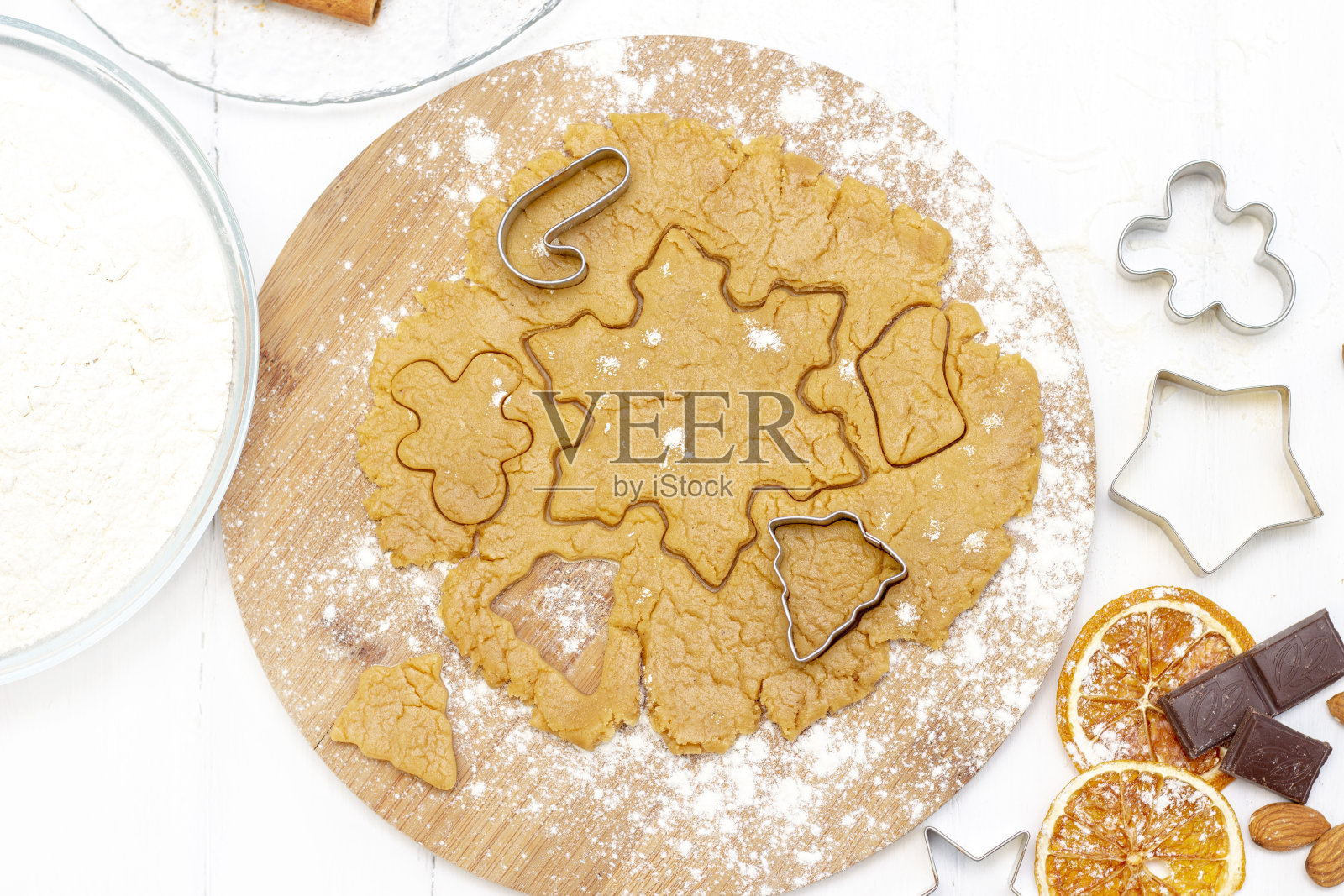 圣诞节的食物。自制的姜饼饼干与圣诞烘焙材料和厨房用具放在白色的桌子上,俯视图。照片摄影图片