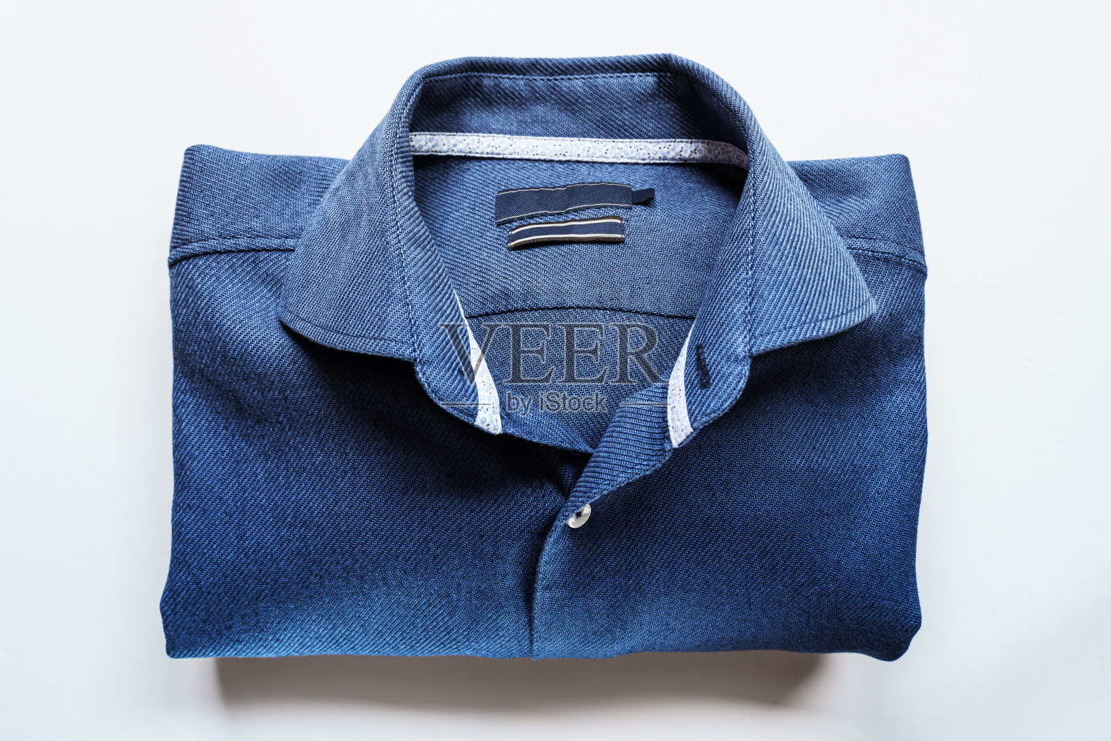 白色背景上的蓝色衬衫照片摄影图片