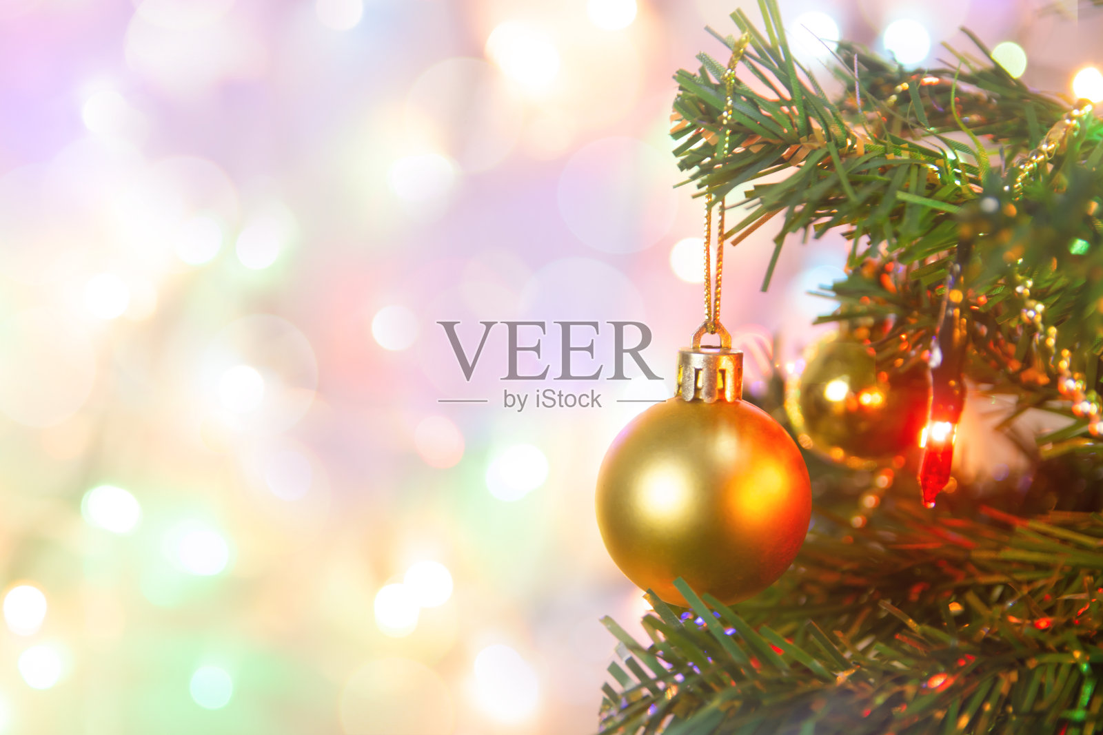 圣诞装饰。在松树树枝上挂金球、圣诞树、花环和装饰物,在抽象的散景背景上复制空间照片摄影图片