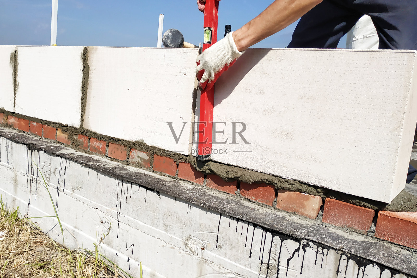 工人用水平仪测量工作墙。照片摄影图片