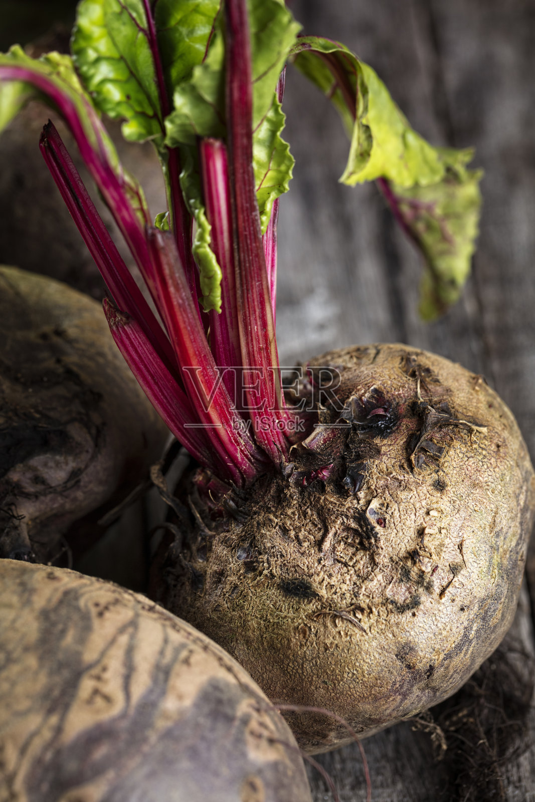 新鲜有机甜菜根的特写放在一张木桌上,垂直构图照片摄影图片