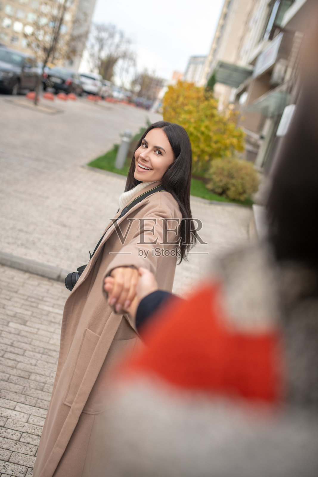 快乐的黑发女人牵着她丈夫的手照片摄影图片