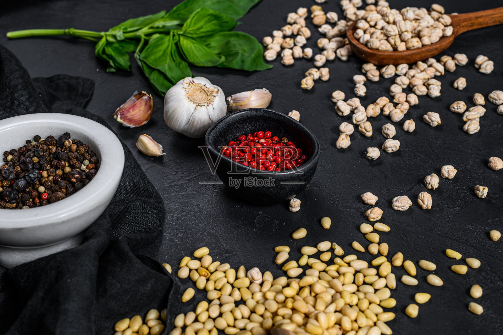 鹰嘴豆泥配料:大蒜、鹰嘴豆、松子、罗勒、胡椒,黑色背景,顶视图照片摄影图片