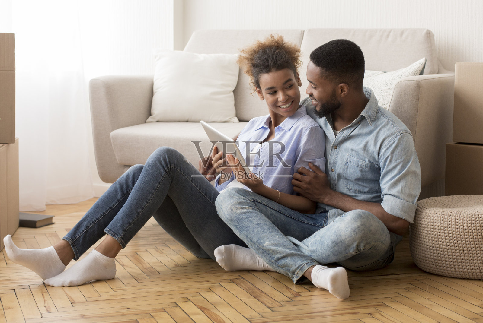 情侣在新公寓的搬家纸箱中使用平板电脑照片摄影图片