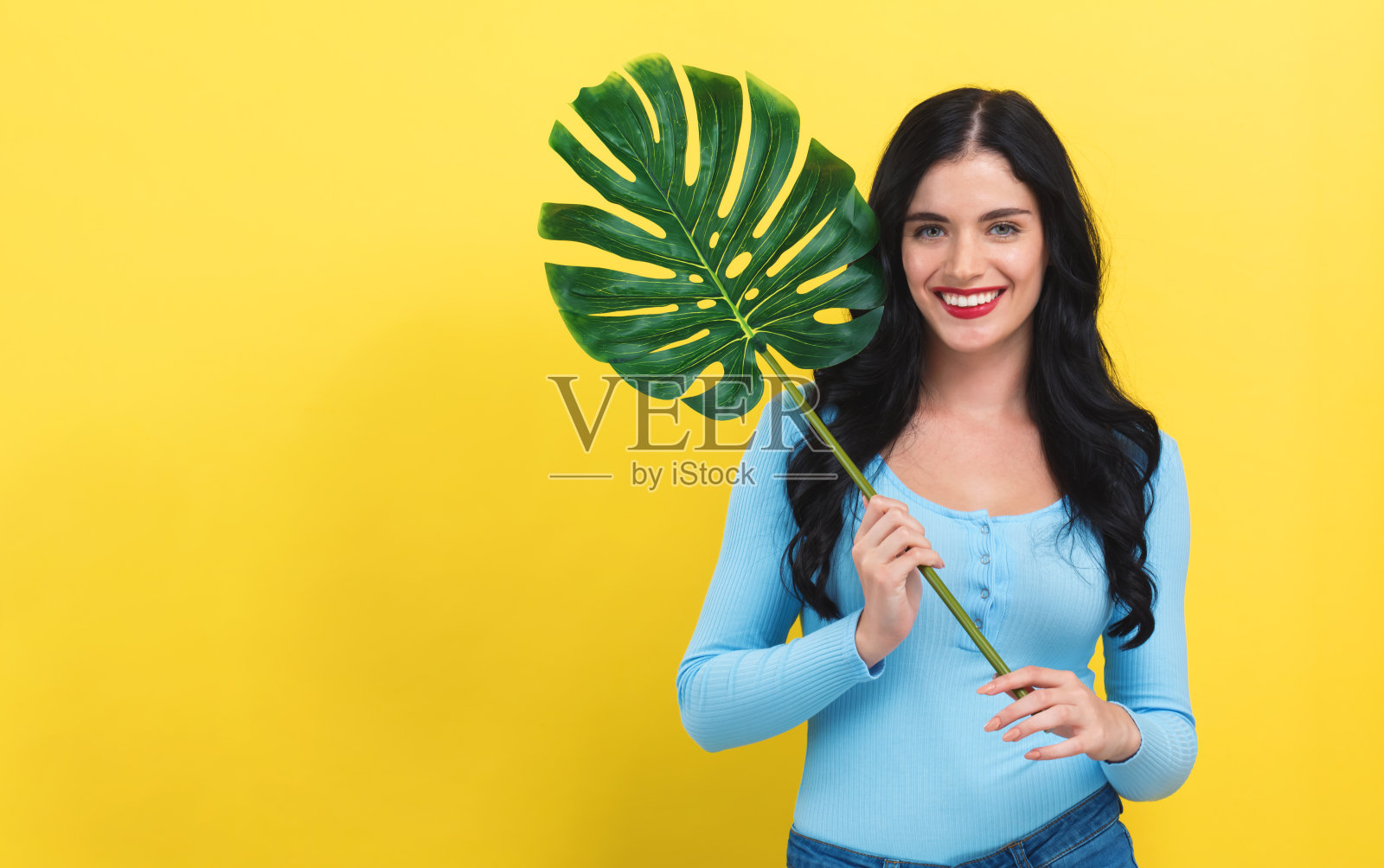 带着热带时尚叶子的年轻女子照片摄影图片