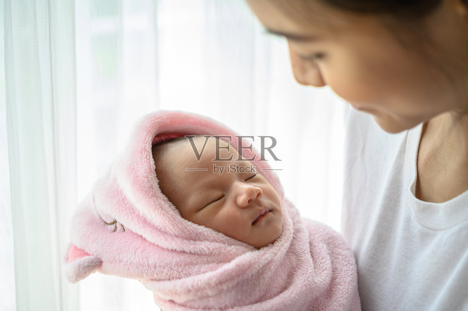 新生婴儿在母亲的怀抱中睡觉照片摄影图片