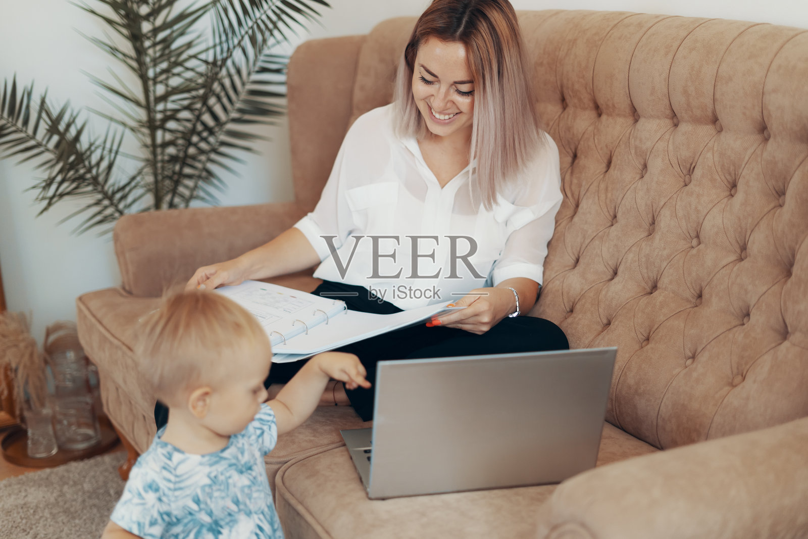 在家工作的漂亮女商人。兼顾多项任务、自由职业和母亲身份照片摄影图片