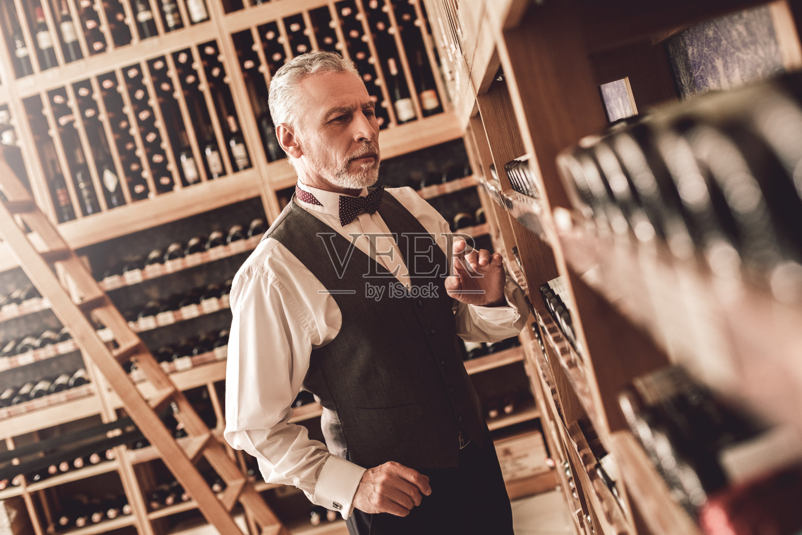 侍酒师的概念。高级男子站在挑选葡萄酒有关照片摄影图片